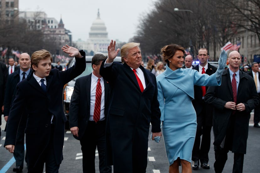 Barron Trump, Donald Trump, and Melania Trump wave while walking from the Capitol building following...