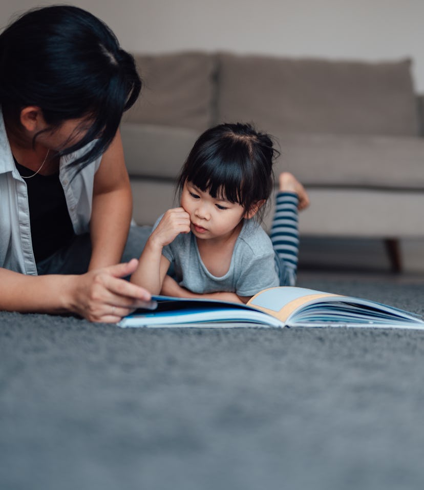 mom reading book to daughter