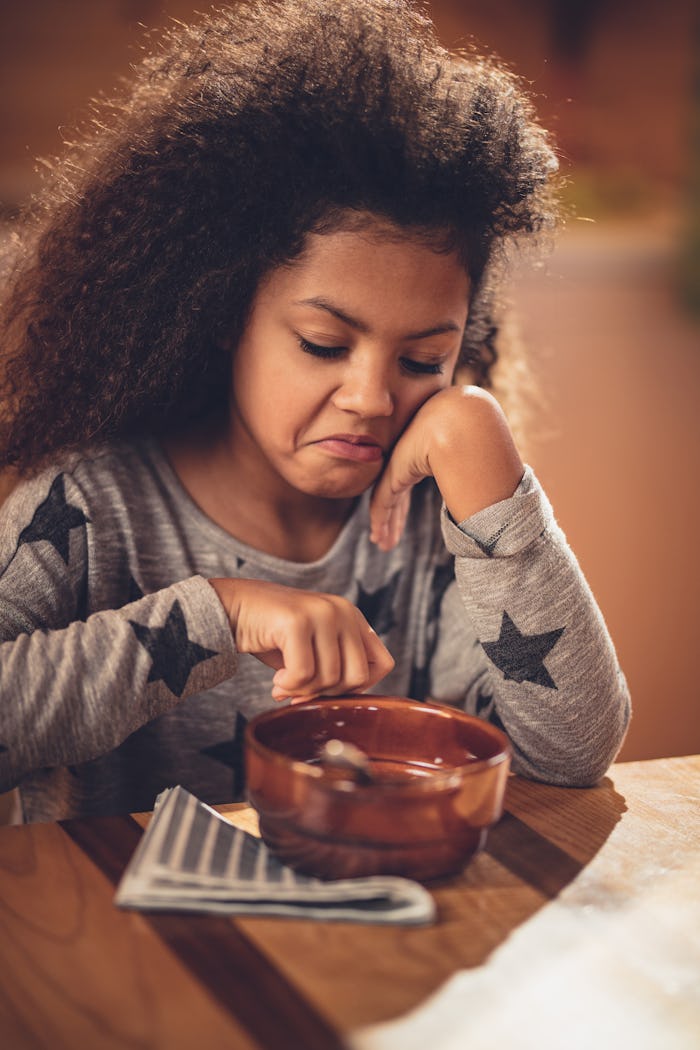 A child who is a picky eater pushing away a bowl of food in disgust