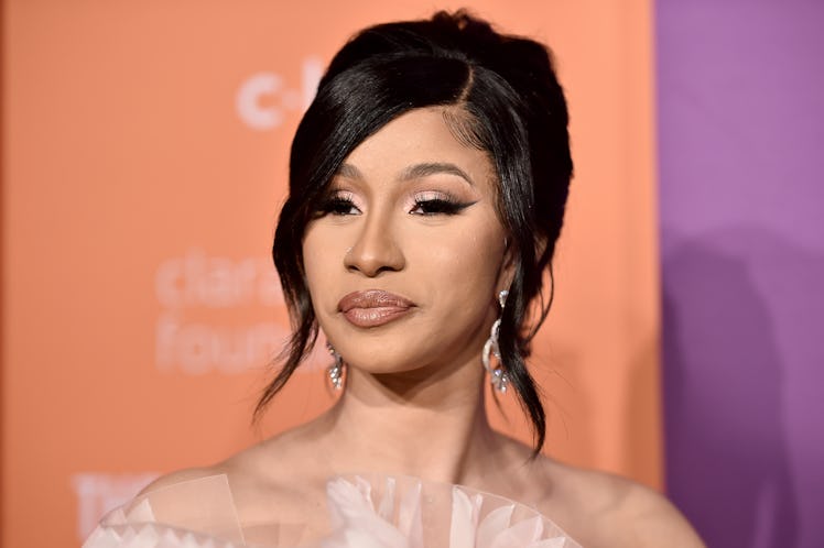 Cardi B poses for photos on the red carpet in a pink ruffle gown. 