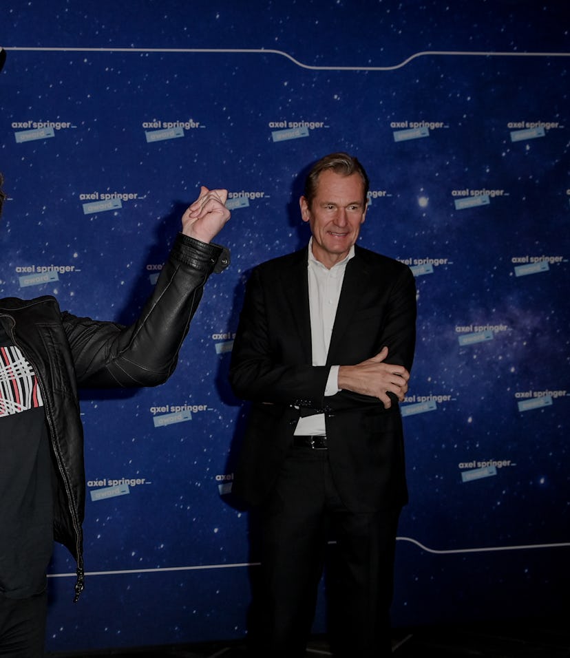 Tesla CEO Elon Musk stands in front of a model rocket.