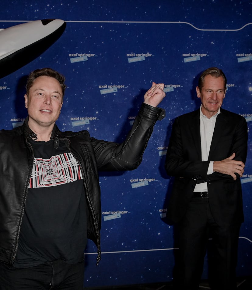 Tesla CEO Elon Musk stands in front of a model rocket. 