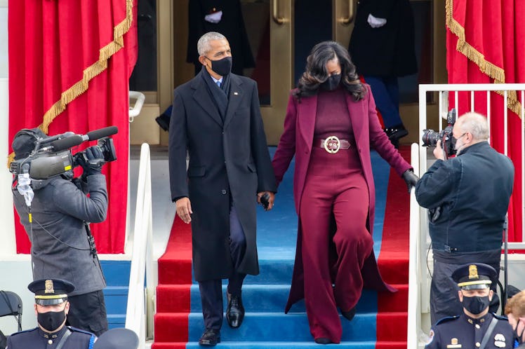Barack Obama and Michelle Obama stepping down the stairs while holding hands.
