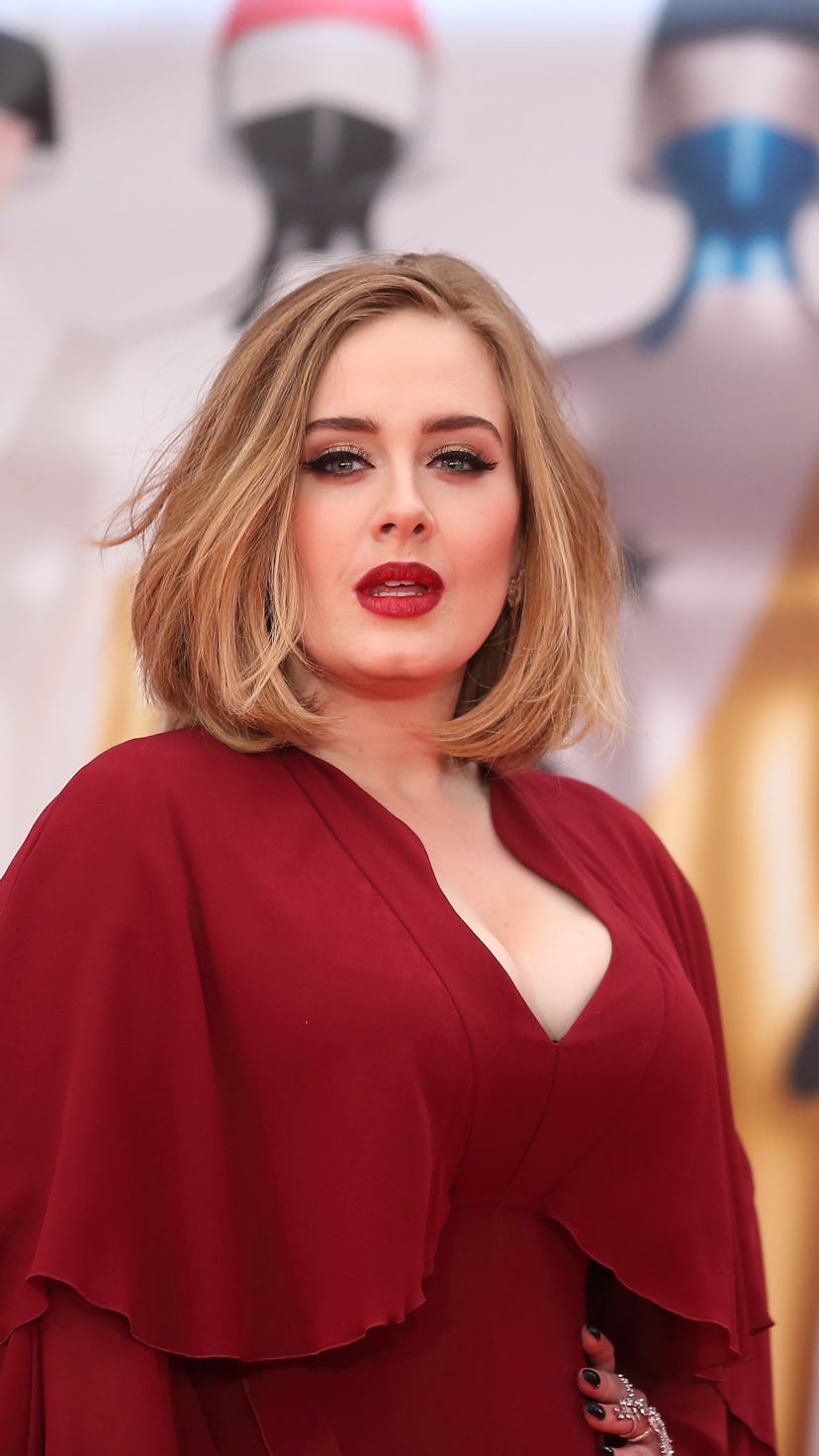 Adele posing in a layered red gown with deep cleavage