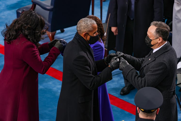 Barack Obama and Michelle Obama fist bump their associates