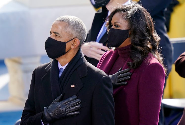 Barack Obama and Michelle Obama standing for the American national anthem