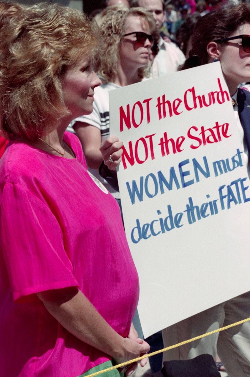 Two women hold a protest sign in support of Roe V. Wade, the 1973 Supreme Court decision legalizing ...