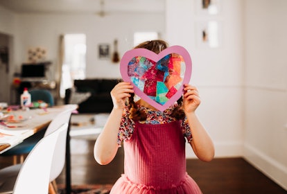 Little girl with a Valentine's Day card full of Valentine's Day jokes.