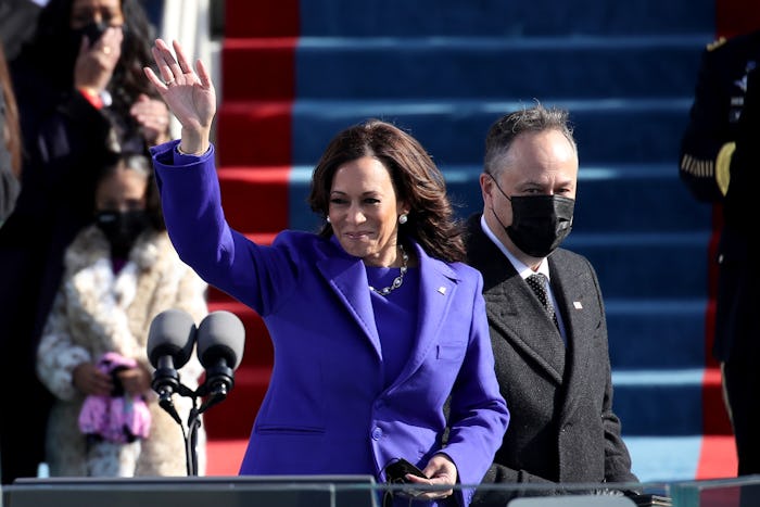 Kamala Harris waves to the Inauguration crowd, her husband Doug Emhoff behind her.