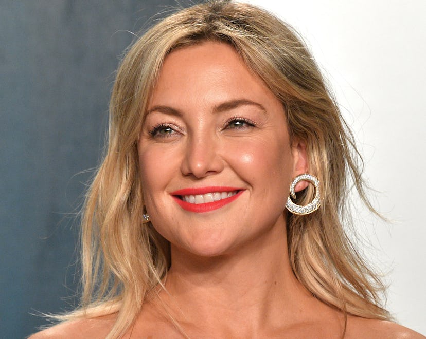 Actor Kate Hudson smiling in a green gown.