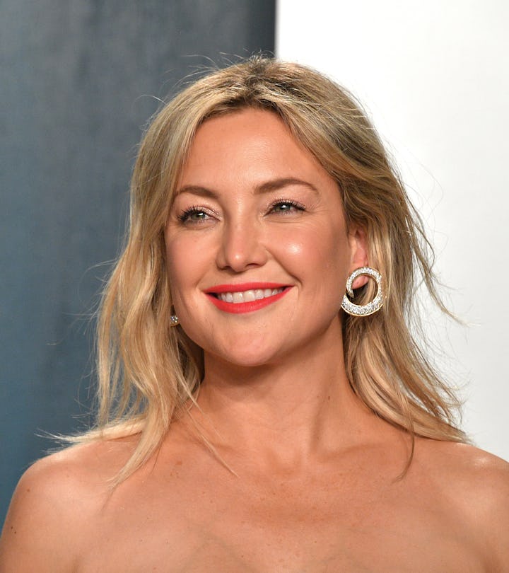 Actor Kate Hudson smiling in a green gown.