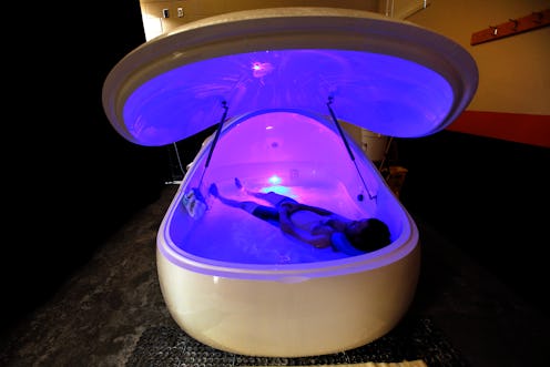 A person floats in a sensory deprivation tank.