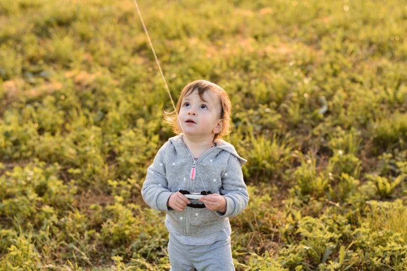 child flying kite. image used to illustrate the name "Huck" in an article about baby names for aquar...