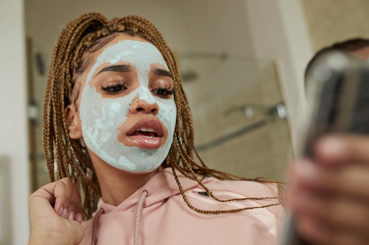 A single woman poses for a selfie while doing a face mask on Valentine's Day.