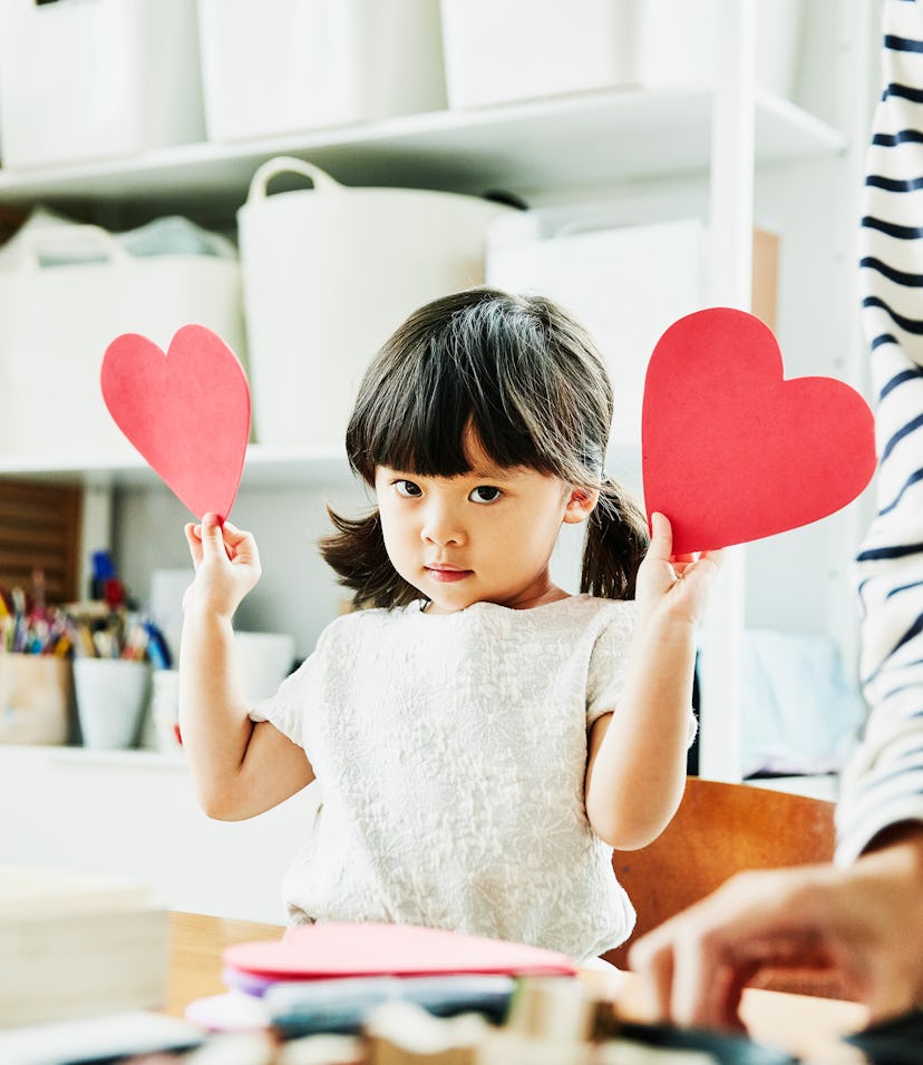 little girl with two valentine's heart cards