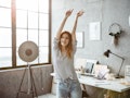 A woman dances in her living room at home while filming a TikTok video.