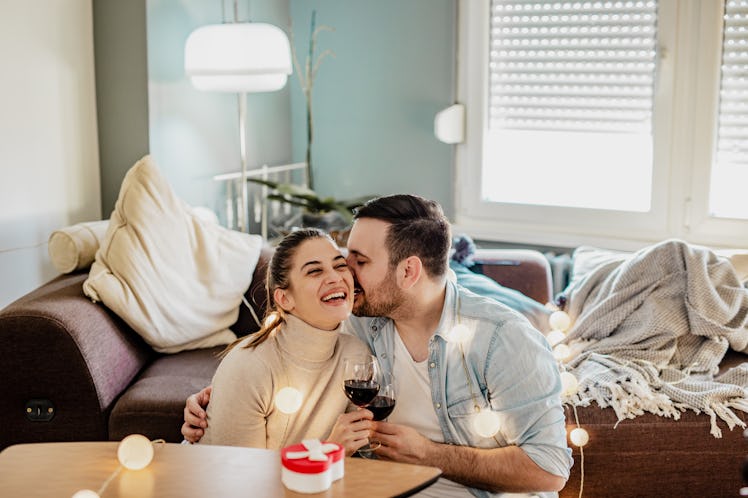 A couple drinks wine and exchanges Valentine's Day gifts.