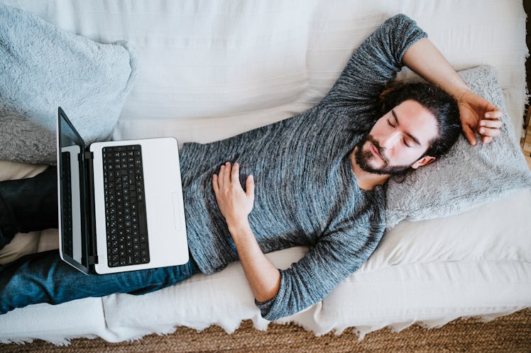 man sleeping on couch with laptop