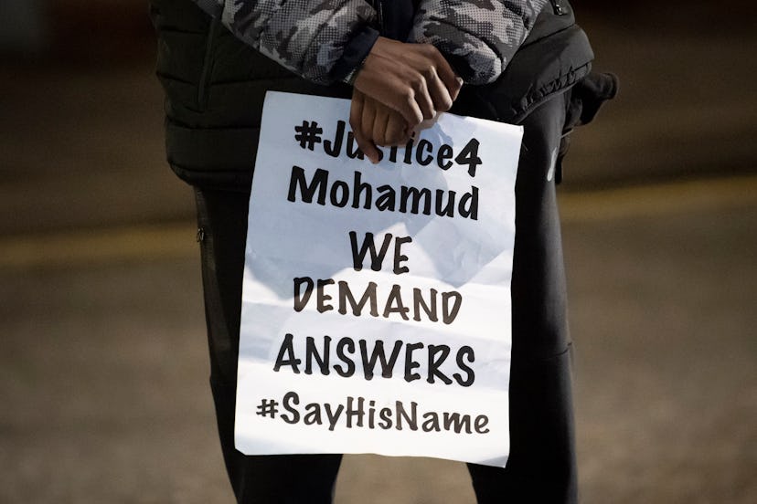 A person holds a sign at a protest for Mohamud Hassan.