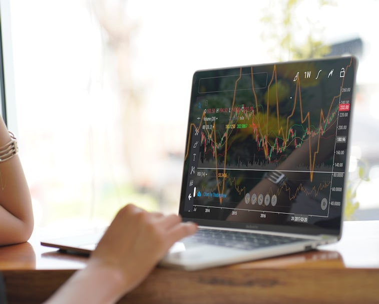 Woman looking at stock charts on a computer.