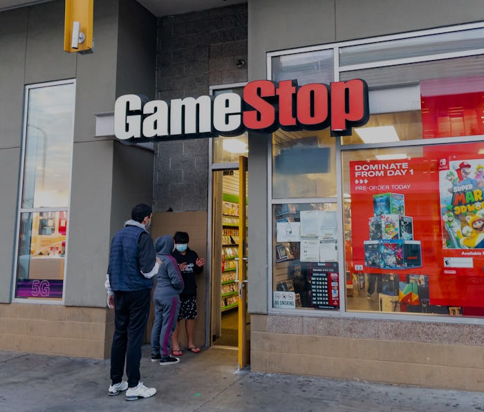 Two pedestrians can be seen outside a GameStop storefront.