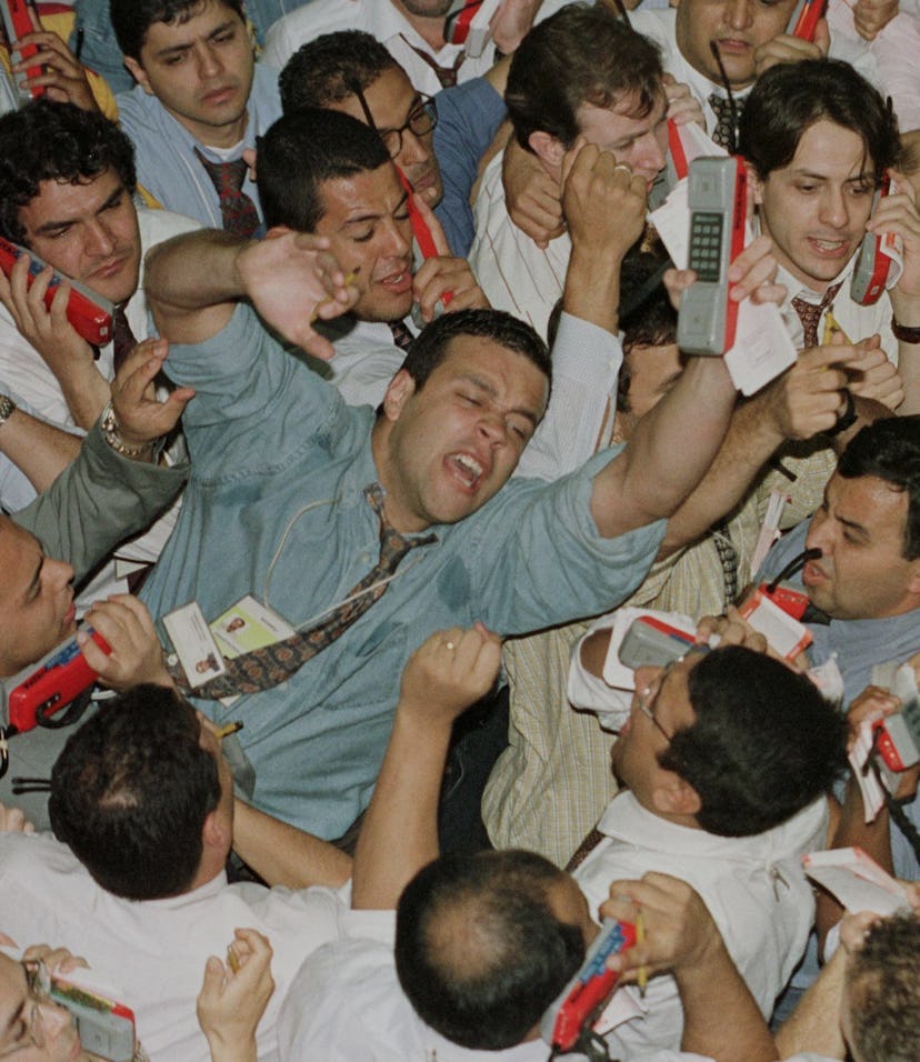 A photo of people panicking on the stock market trading floor.
