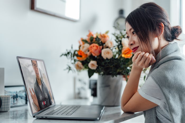 woman with flowers looking at laptop