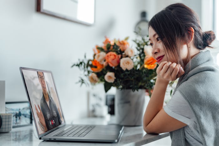 woman with flowers looking at laptop