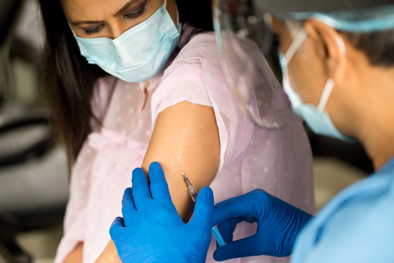 A person wearing a mask receives a vaccine shot in their left arm. It's perfectly normal for your ar...