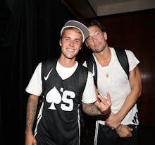 Justin Bieber in a black jersey with a white t-shirt underneath and Pastor Carl Lentz in a plain whi...