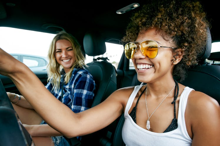 Two friends take a road trip together before quarantine, and laugh in the car.