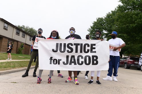 Protestors hold up a sign saying "Justice for Jacob," a reference to Jacob Blake. Here's how to help...