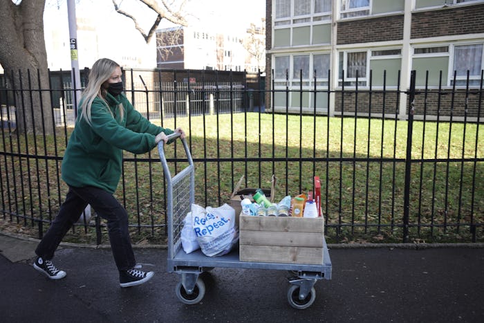 woman pushing cart home from food bank