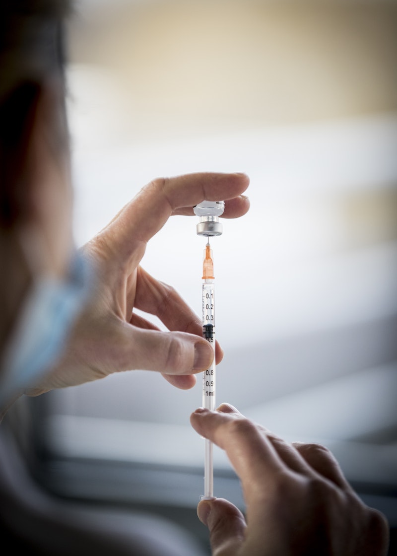 A nurse fills a syringe with Pfizer's COVID-19 vaccine. Here's what you need to know about all the a...