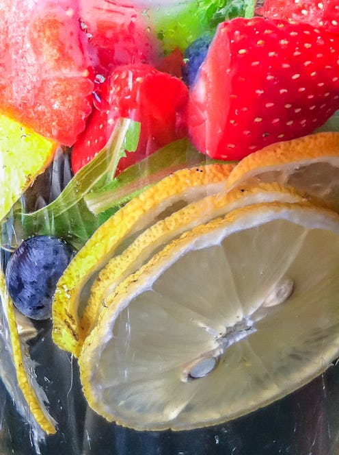 A close up of water infused with lemons, blueberries, and strawberries. TikTok videos about being hy...