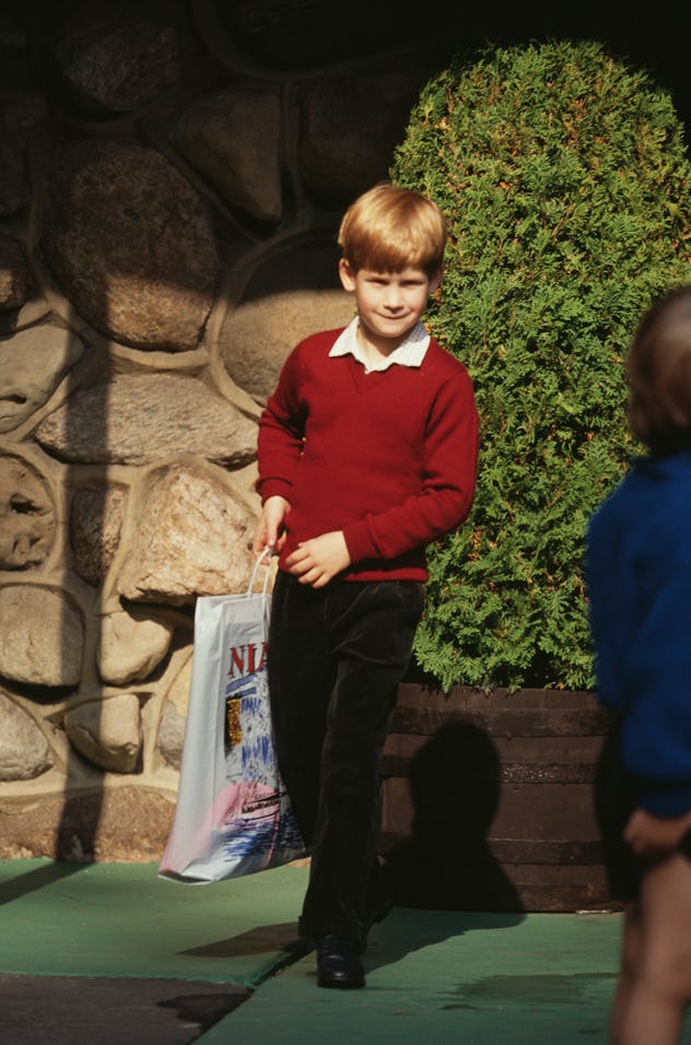 Prince Harry wears a sweater with long pants.