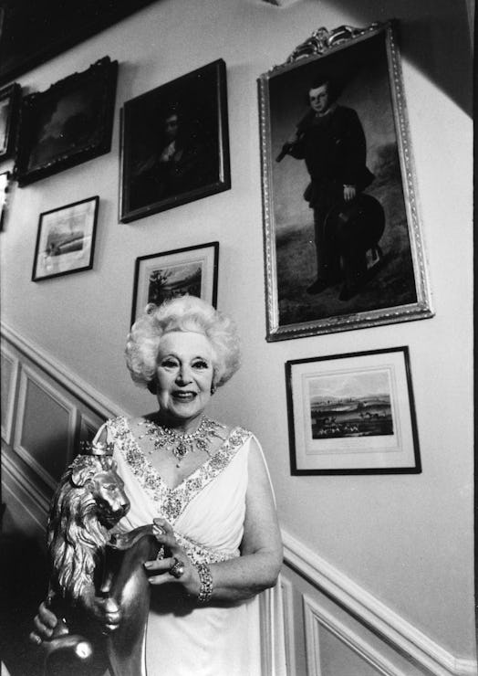 Dame Barbara Cartland (1901-2000) English author of romance novels, on the staircase of her home in ...