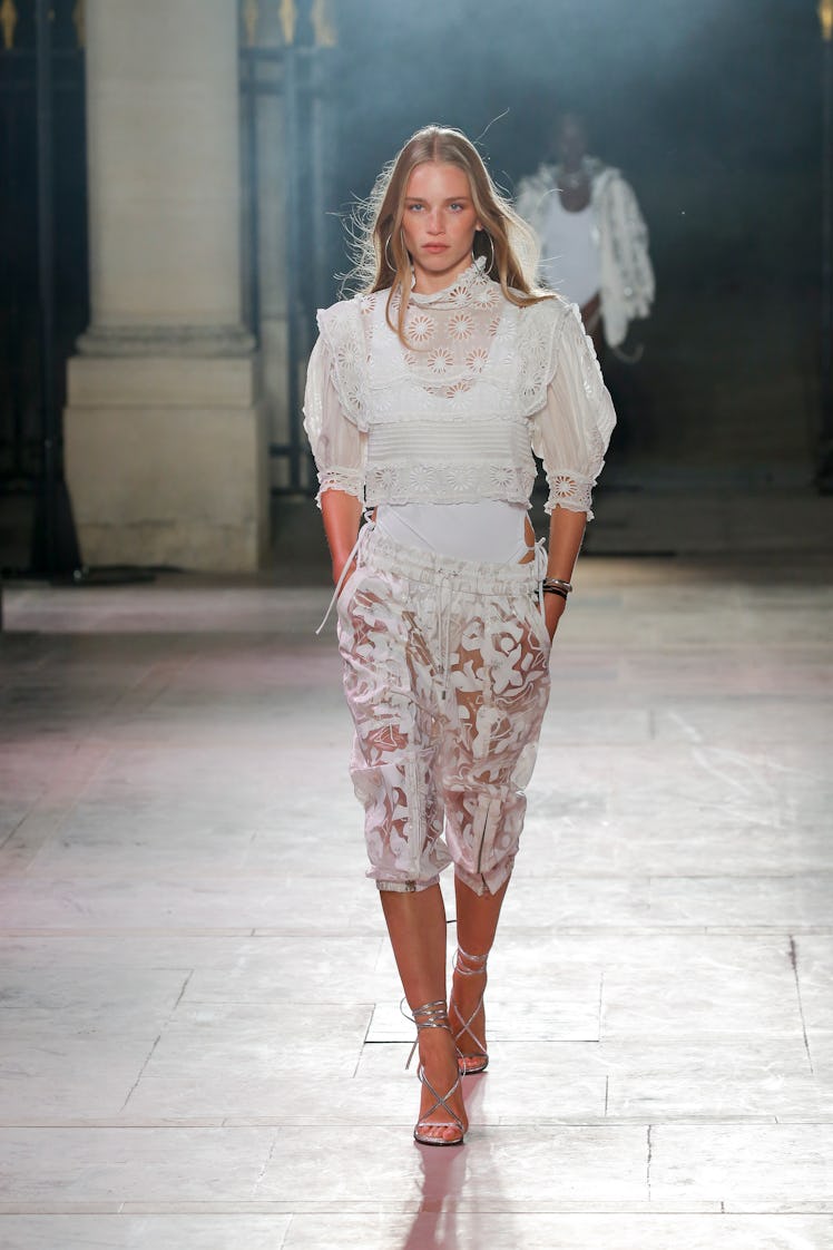 A model walking in a white lace dress at the Isabel Marant Ready to Wear Spring/Summer 2022 fashion ...