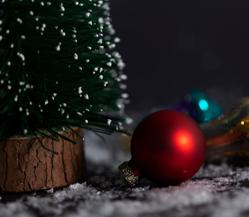 Christmas tree with Christmas decoration and Christmas light against snow  black background