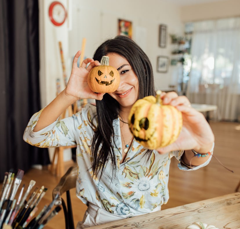 Young woman holding Jack O’ Lanterns in her hand for Halloween
