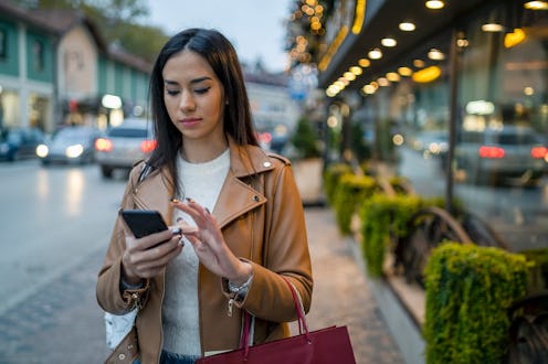 Happy woman holding shopping bags in her hand and shopping gifts for Christmas.