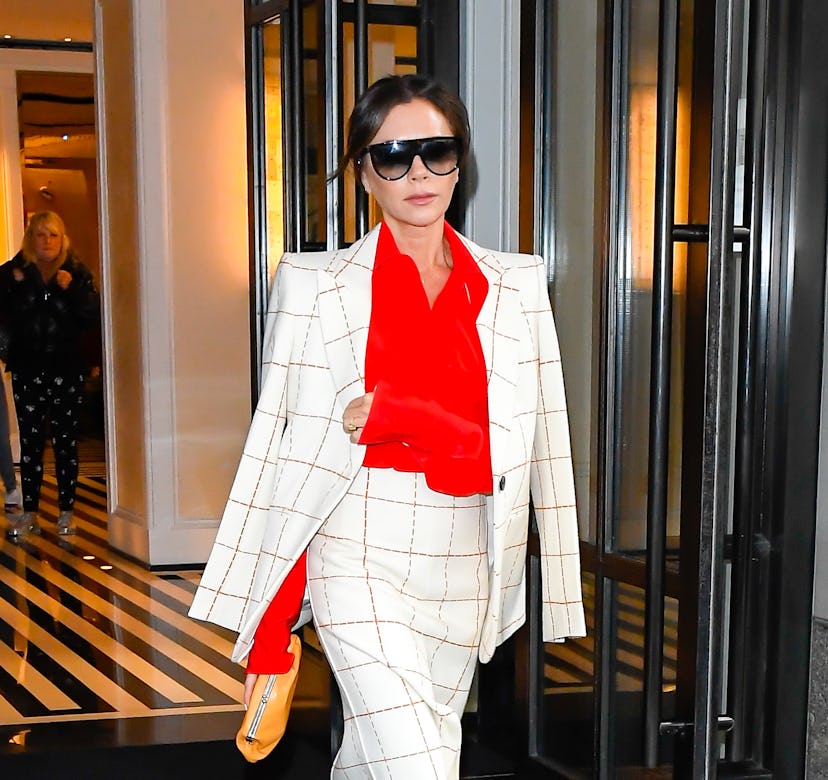 Victoria Beckham wearing a colorful red blouse. 