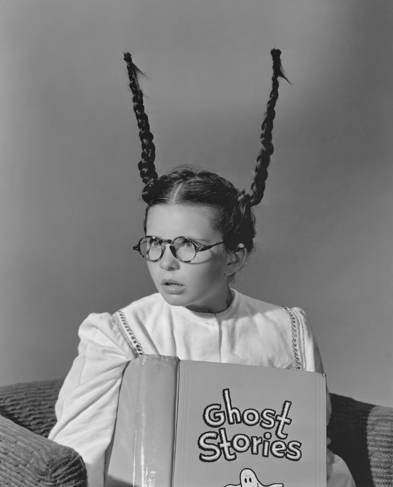 A girl reading ghost stories with her pigtails standing on end. These creepy ghost story podcasts ar...