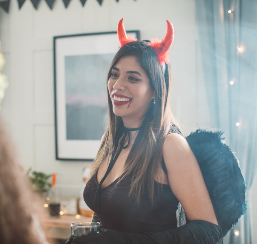 Group of Young people at home celebrating Halloween in costumes, they enjoy in good atmosphere