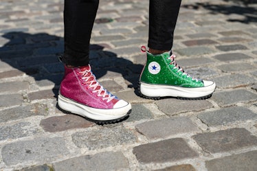 A pair of sparkle pink and green Converse on the street.