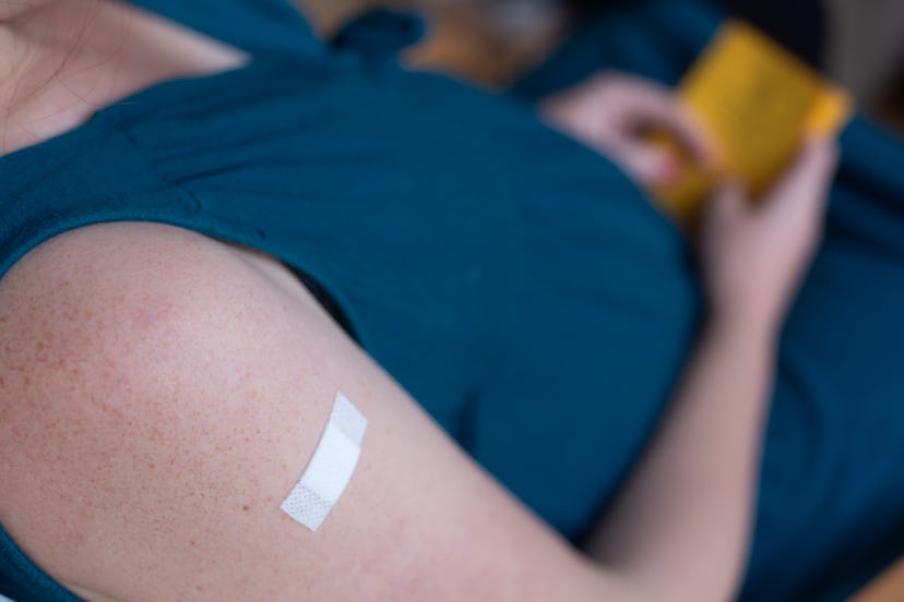 PRODUCTION - 24 September 2021, Berlin: A pregnant woman holds her vaccination certificate (vaccinat...