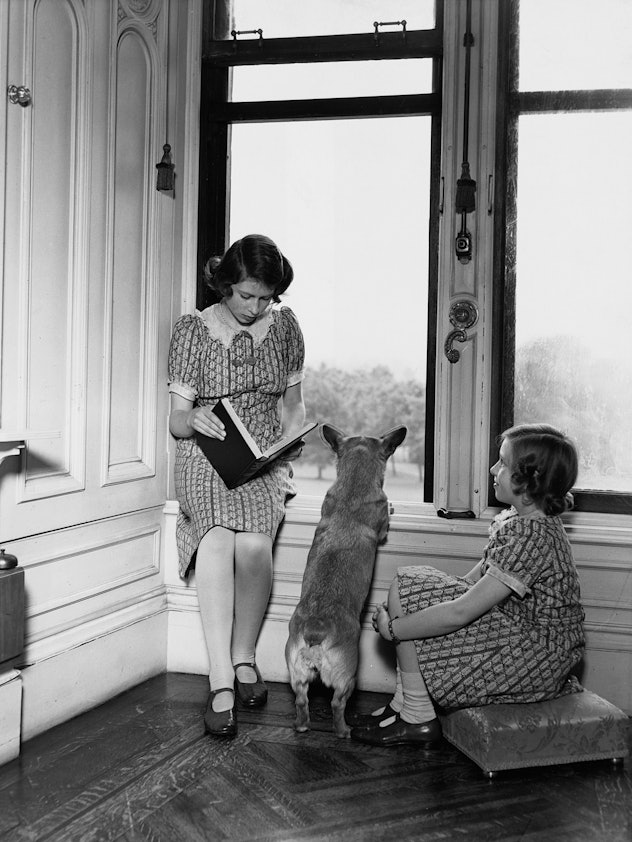 Queen Elizabeth reads with her dog and her sister.