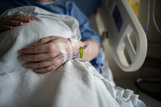 A hospital patient is receiving intravenous therapy in their hand.