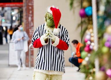 VANCOUVER, BRITISH COLUMBIA - DECEMBER 24: An employee of Foot Locker dressed as Grinch is seen posi...