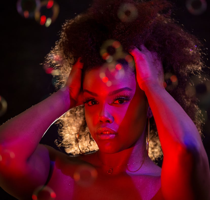 Woman standing in front of red light, the November 2021 new moon in Scorpio will affect her zodiac s...